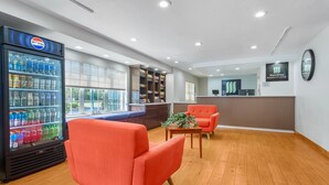 A lobby with a refrigerator stocked with beverages, a reception desk, and seating areas. - MainStay Suites Tampa Moffitt-USF (Tampa)