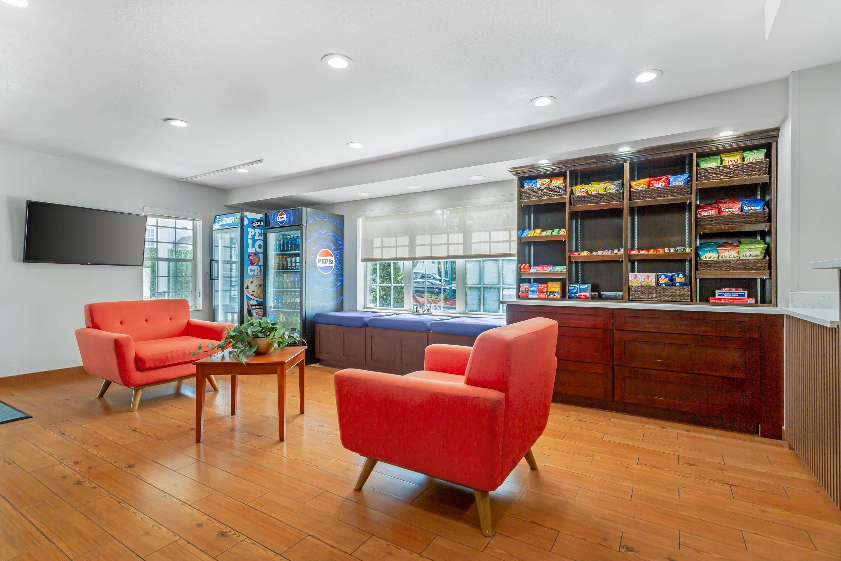 A modern lobby with a seating area, a reception desk, and a snack bar.