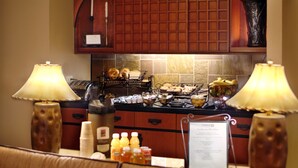 A kitchen with a breakfast bar, a coffee station, and a menu sign.