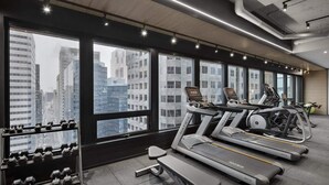 Ein modernes Fitnessstudio mit Laufbändern, Kurzhanteln und Trainingsgeräten.
