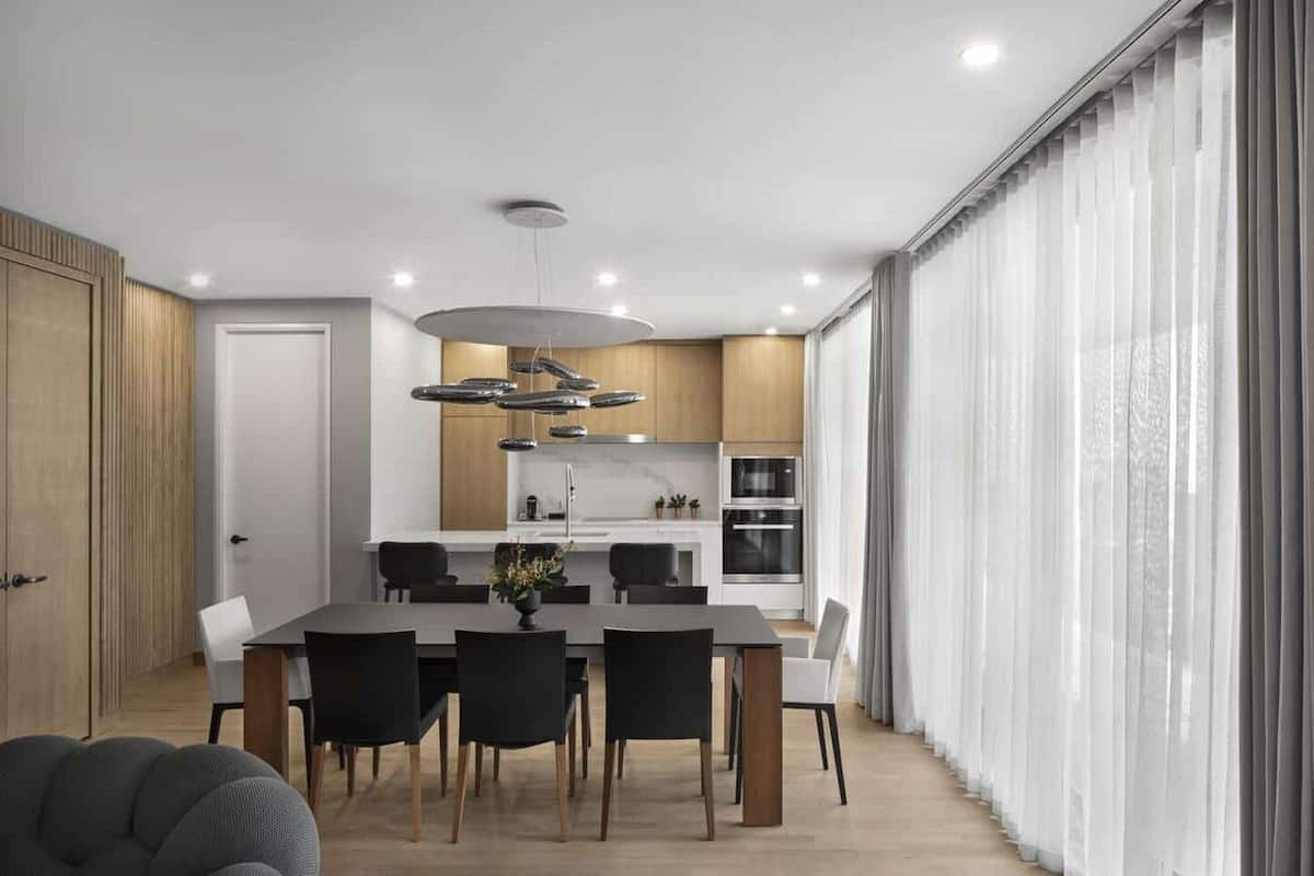 A modern kitchen with a central island, wooden cabinets, and stainless steel appliances.