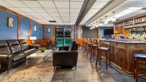 A bar area with a counter, stools, and a variety of bottles. - Wingate by Wyndham - Round Rock (Round Rock)