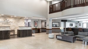 A spacious lobby with a reception desk, seating area, and a staircase. - Wingate by Wyndham - Round Rock (Round Rock)