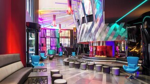 A modern lounge area with seating, tables, and a bar. - W Seattle (Seattle)