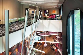 A modern lobby with a seating area, a staircase, and a large window. at W Seattle