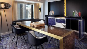 A modern hotel room with a dining area, a sofa, and a bar counter. - W Seattle (Seattle)