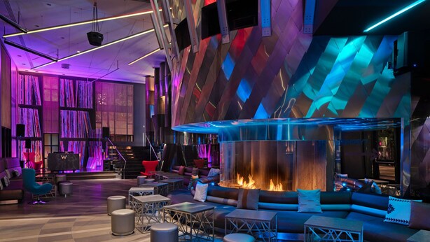A modern lounge area with a central fire feature, seating arrangements, and a geometric wall design. - W Seattle (Seattle)