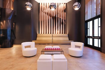 A modern hotel lobby with a reception desk, a large window, and a geometric floor pattern. at W Seattle
