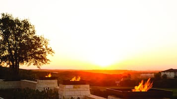A sunset view with two fire pits in a stone structure.