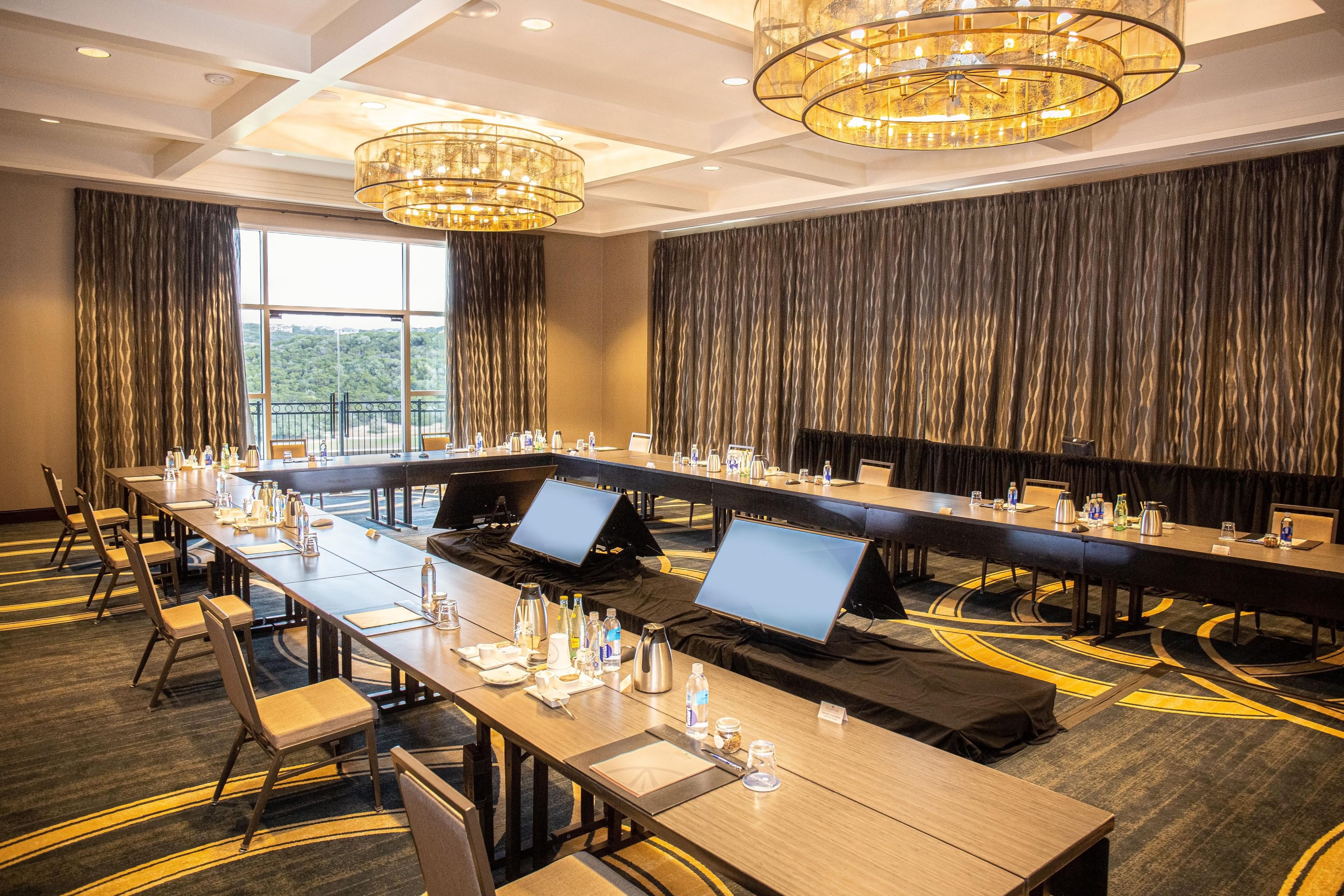 A conference room with long tables, chairs, and laptops.