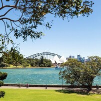 Un parque con vistas a la Ópera de Sydney y al Puente de la Bahía.