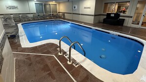 Una piscina con un cartel de salvavidas y dos carteles de prohibido bucear.