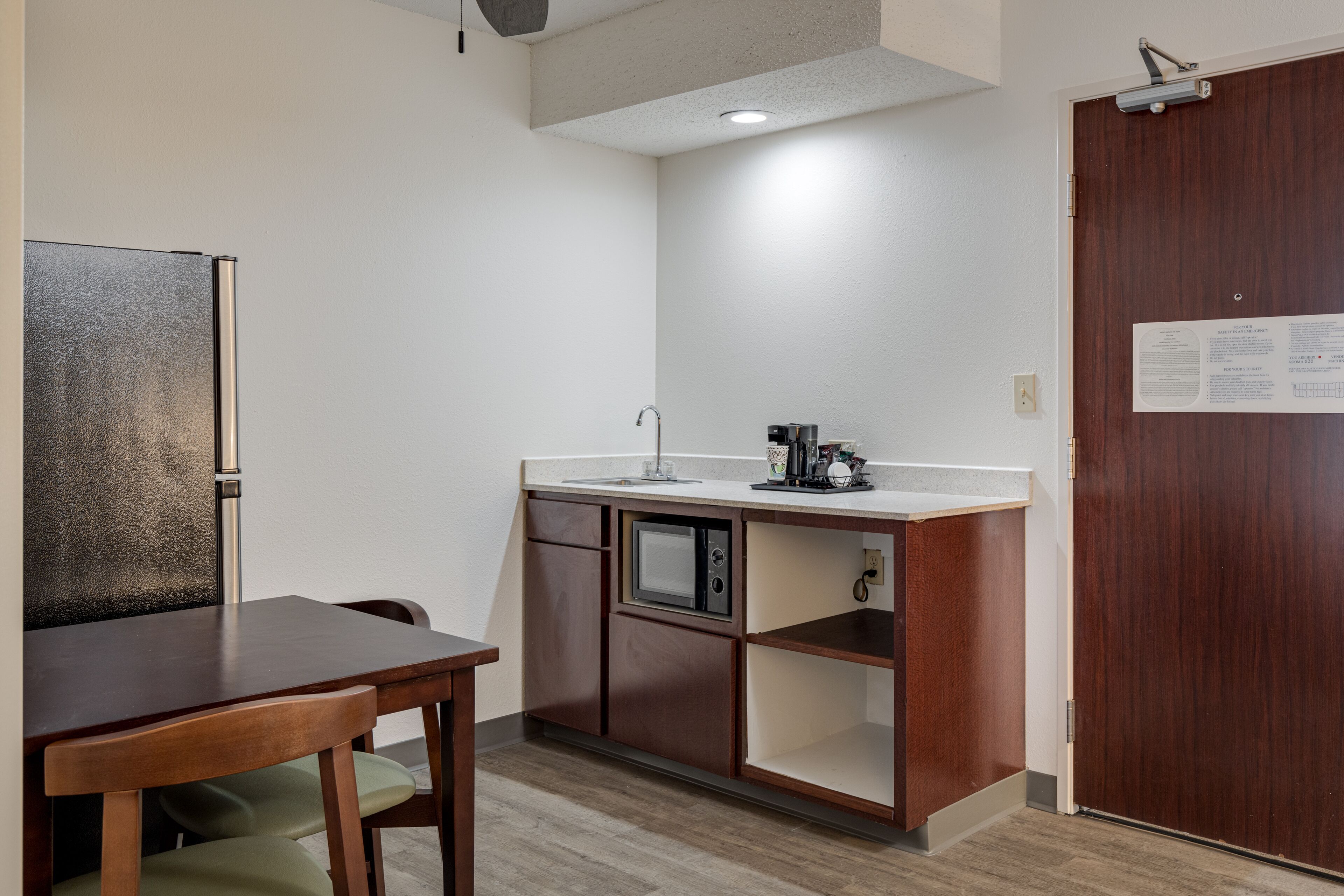 A compact kitchen with a microwave, coffee maker, and a small refrigerator.