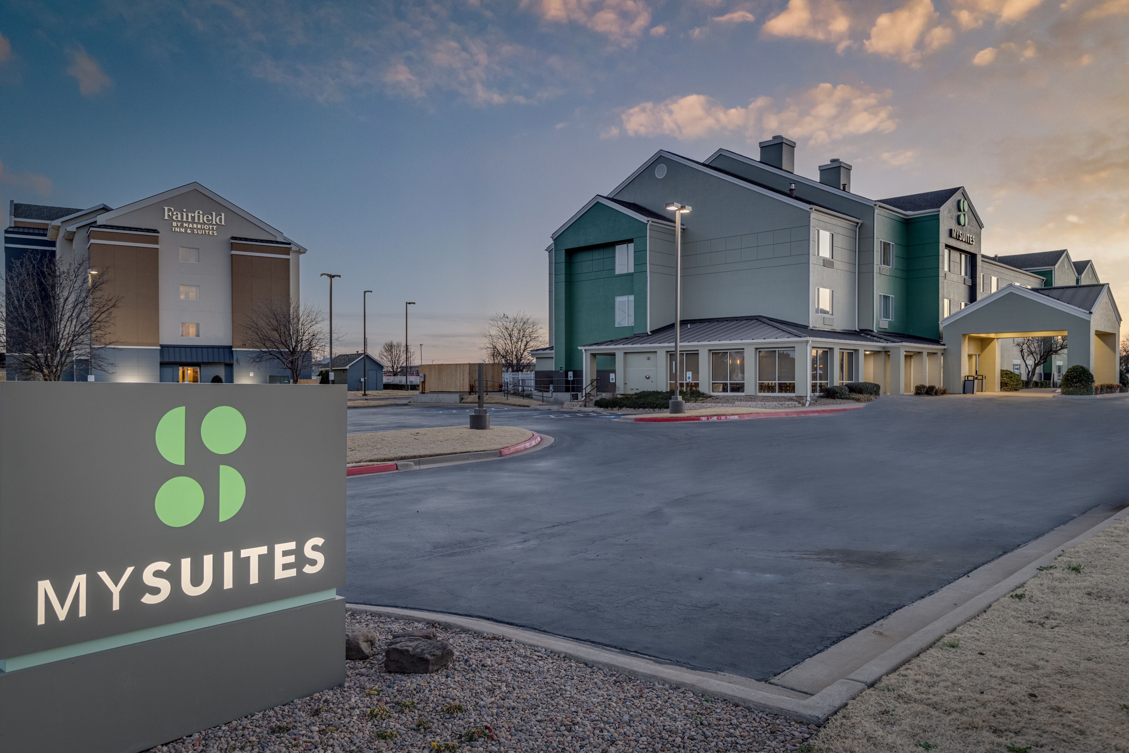 Een hotel met een modern design, met een groot bord waarop het logo en de naam 'MYSUITES' staan.