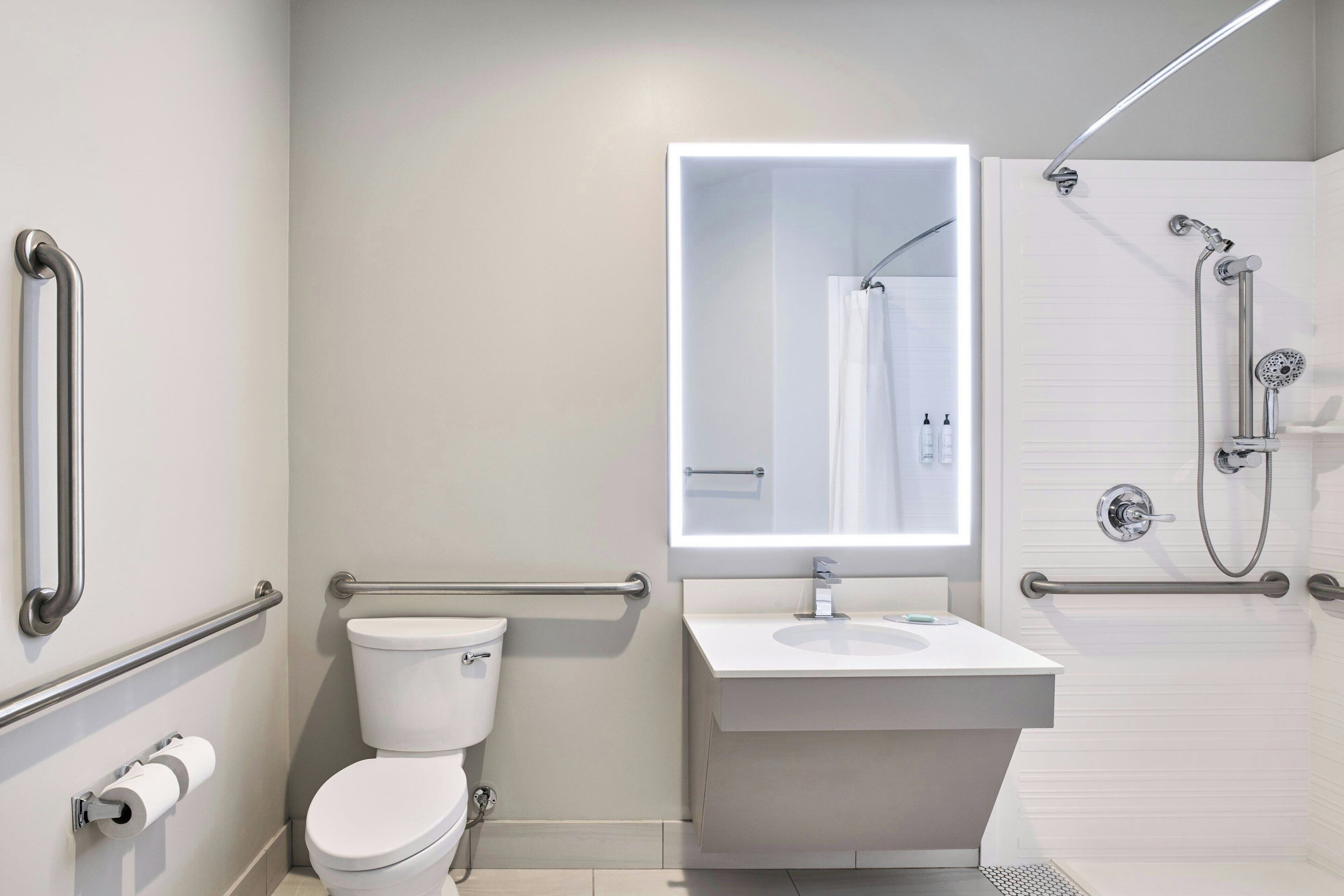 A modern bathroom with a toilet, sink, and shower.