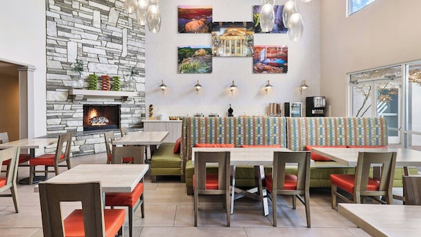 Ein Restaurant mit Steinwand, mehreren Tischen und einem Kamin.