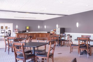 Enjoy meals in this stylish dining area with a bar, tables, and comfortable seating.