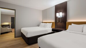 A hotel room with two beds, a desk, and a chair. - The Marco Hotel Lake Charles (Lake Charles)