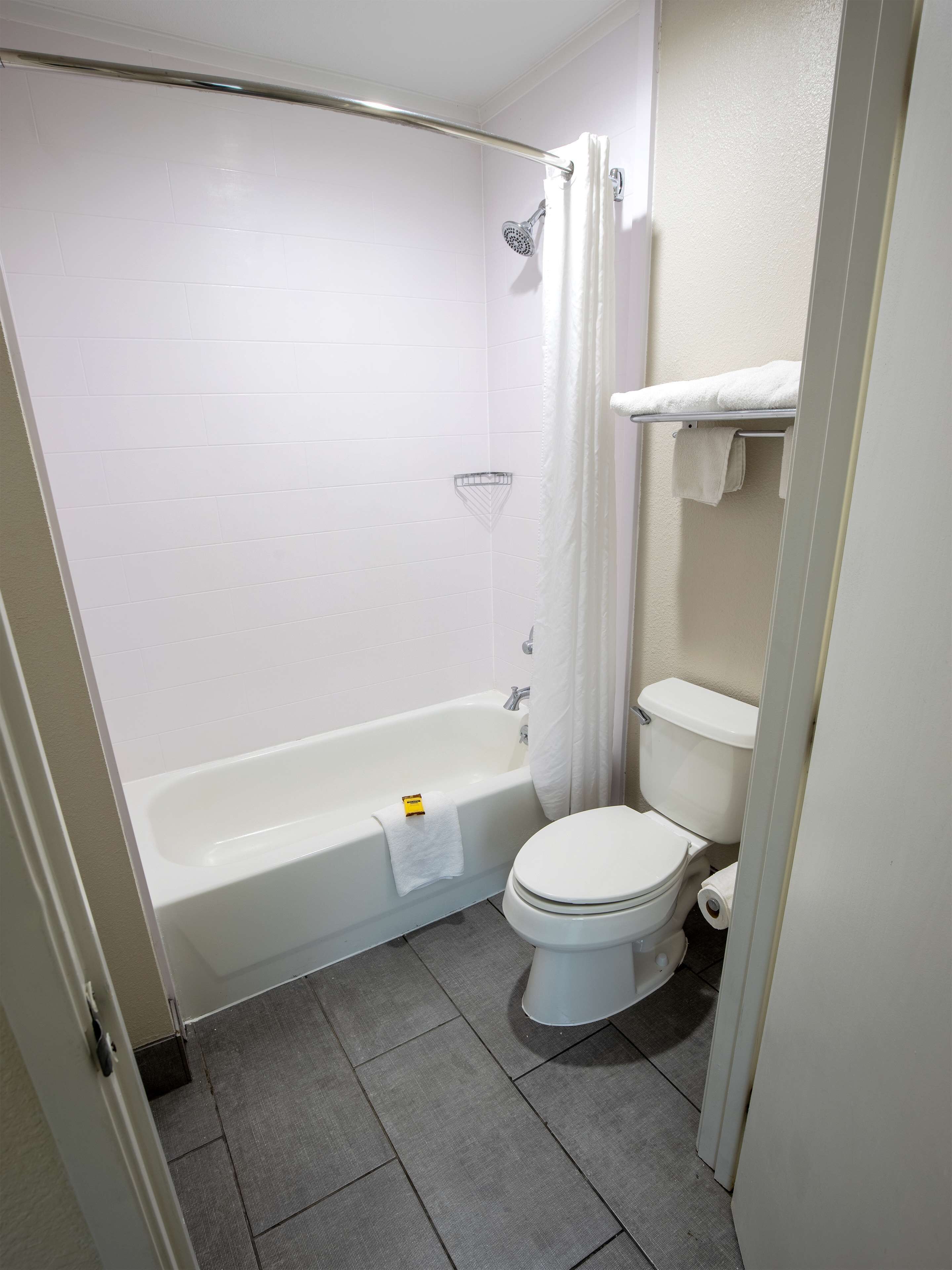 Une salle de bain avec une baignoire, des toilettes et un rideau de douche.
