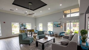 A spacious living area with multiple seating options, a coffee table, and a dining area with chairs and a table.
