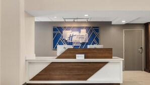 A reception desk with a modern design, featuring a blue and white color scheme and geometric patterns on the wall behind it.
