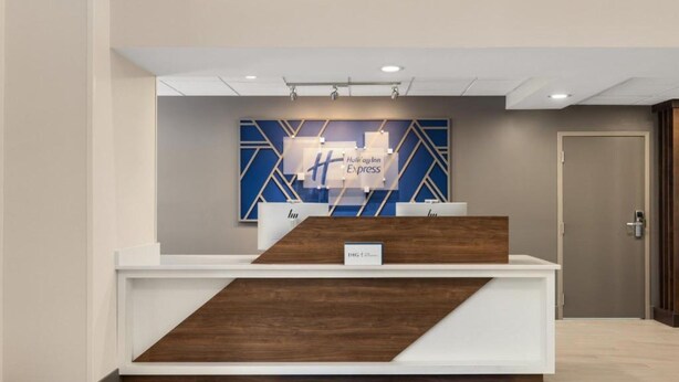 En reception med et moderne design, med blå og hvide farver samt geometriske mønstre på væggen bagved.