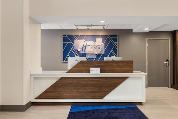 Una reception dal design moderno, con una combinazione di colori blu e bianco e motivi geometrici sulla parete retrostante.