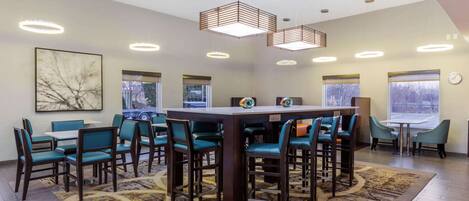A modern dining area with a central table, multiple chairs, and pendant lighting.
