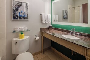 Un baño con inodoro, lavabo, espejo y perchero para toallas.