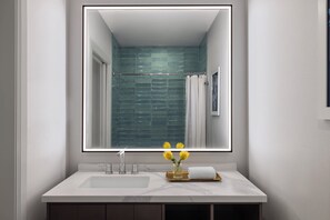 A modern bathroom with a large mirror, white sink, and a glass shower enclosure. - Kimpton Hotel Monaco Salt Lake City by IHG (Salt Lake City)