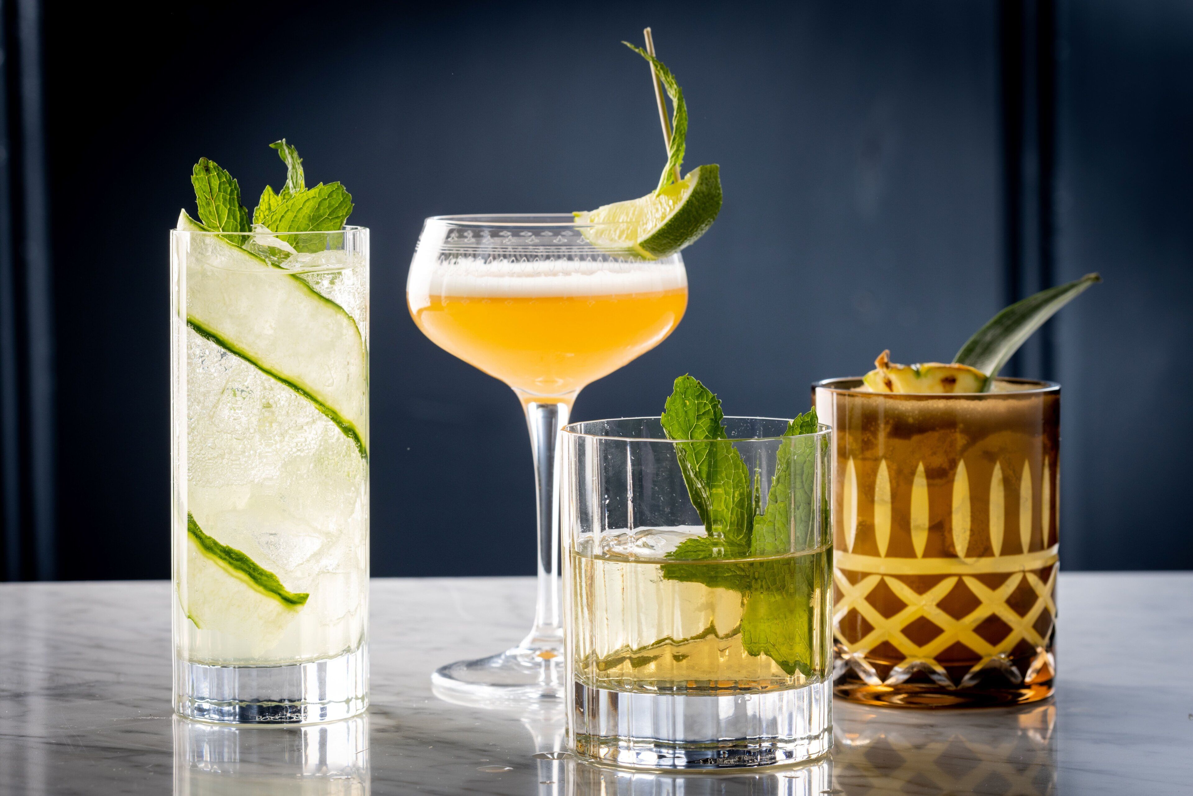 Three different types of glasses with various garnishes.