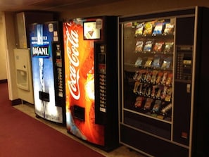 A row of vending machines with various brands, including Coca-Cola, and a refrigerator. - Country Hearth Inn & Suites Willard (Willard)