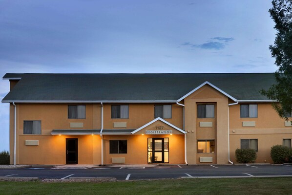Ein Hotel mit einer Rezeption, mehreren Fenstern und einem Parkplatz.