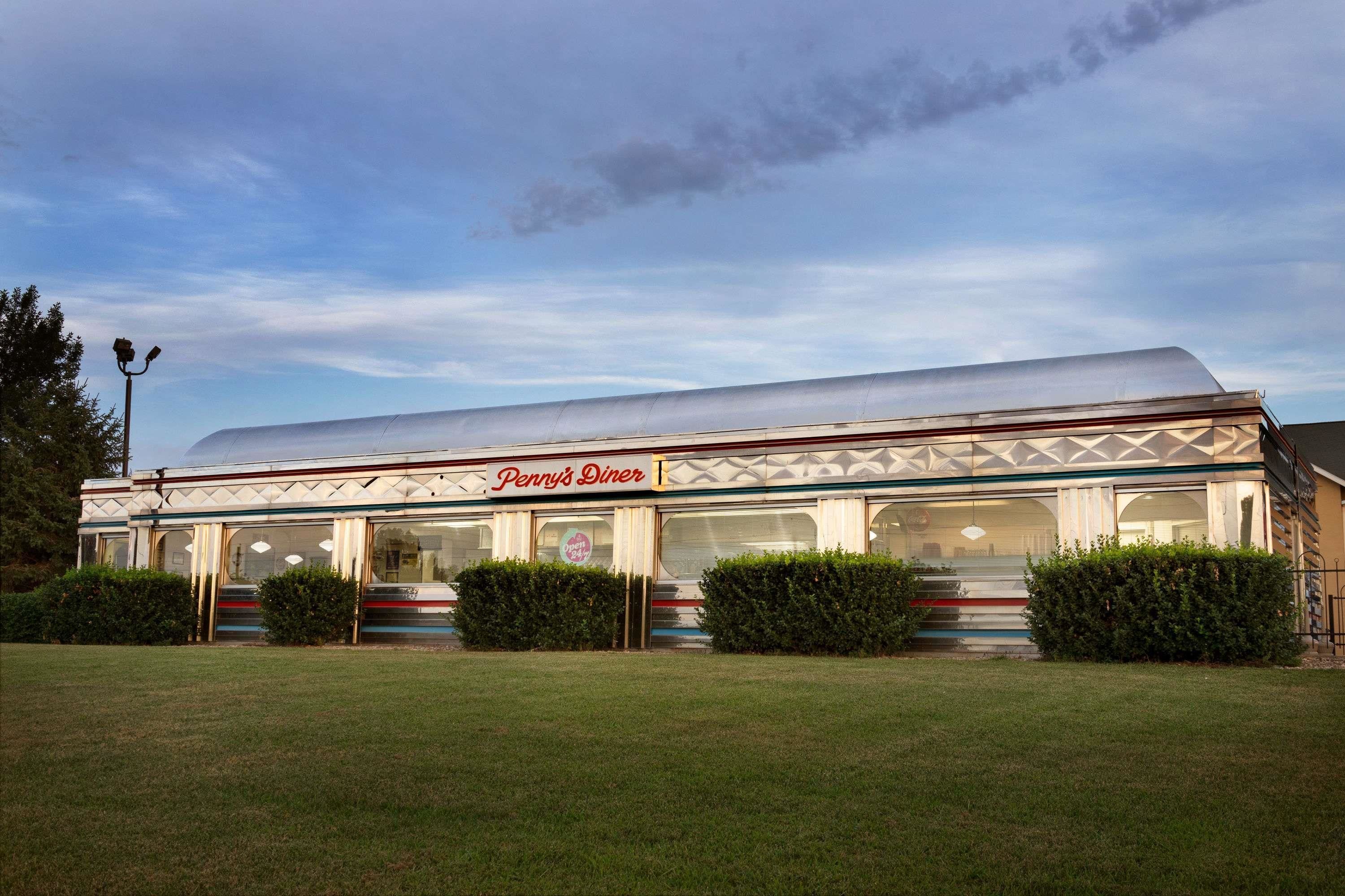 A diner with a large, sloped roof and a sign reading "Penny's Diner."