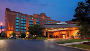 Un hotel Marriott con fachada de ladrillo moderno, grandes ventanales y una entrada bien iluminada.