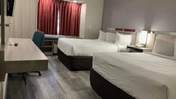 Quarto de hotel com duas camas, uma escrivaninha e uma cadeira.