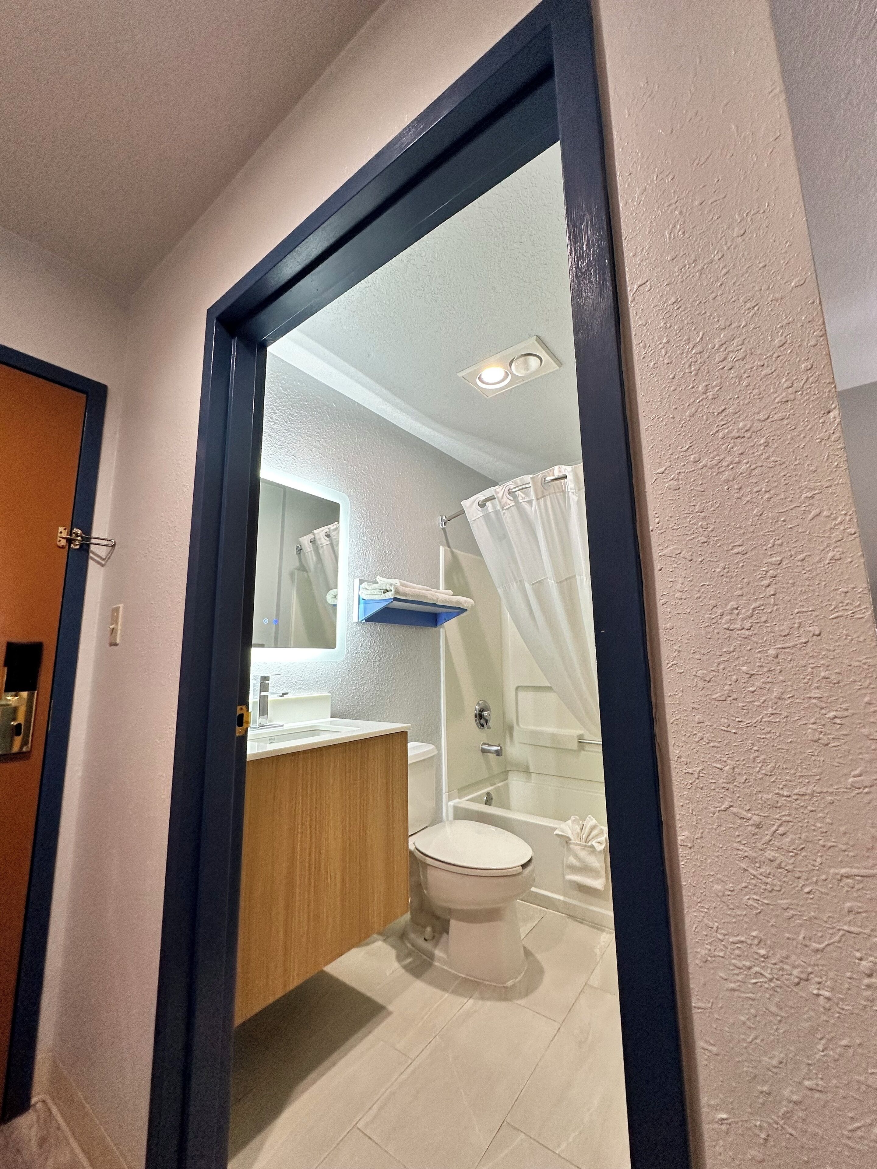 A bathroom with a toilet, sink, and shower area.