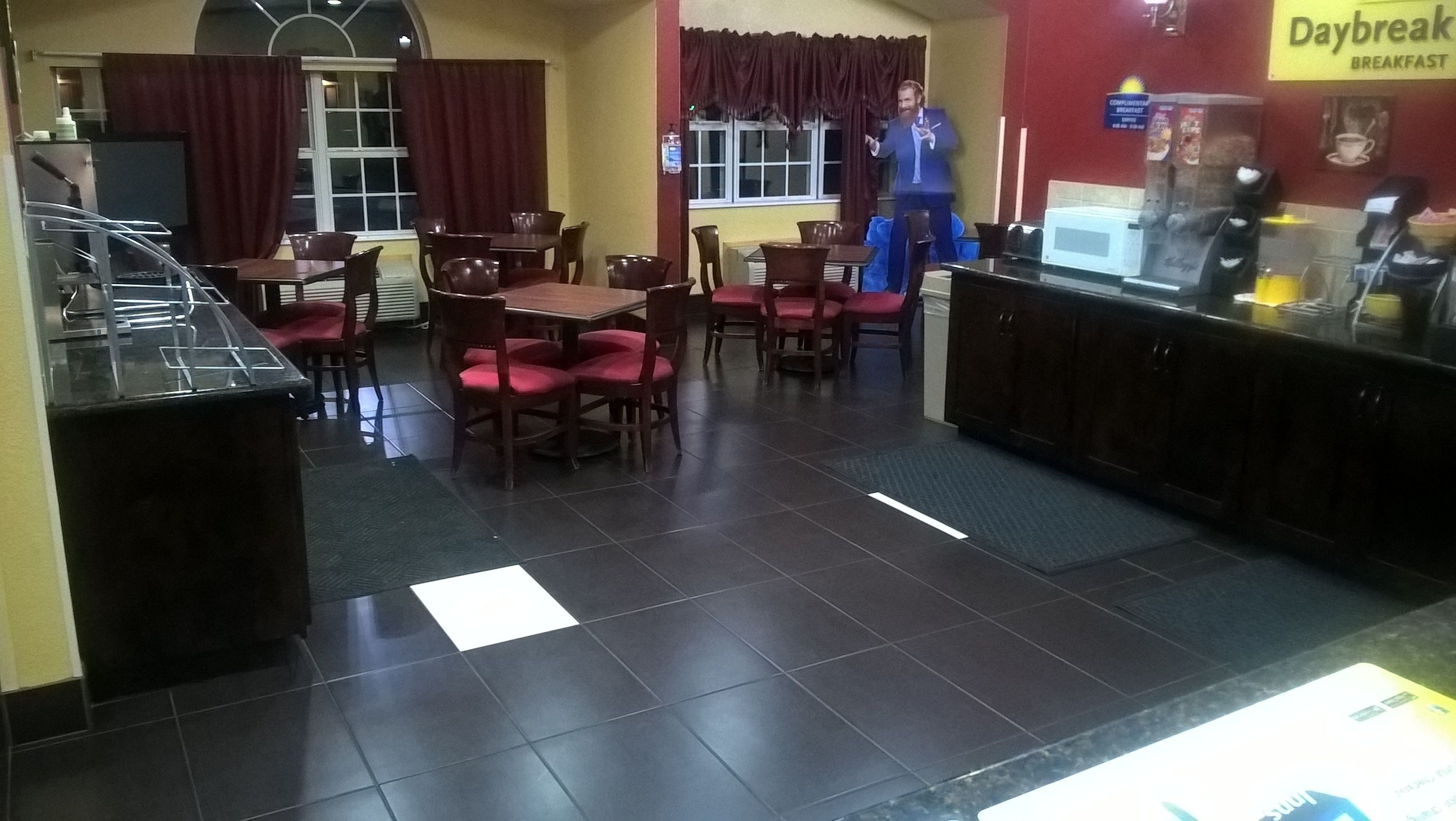 A restaurant with a breakfast counter, tables, and chairs.