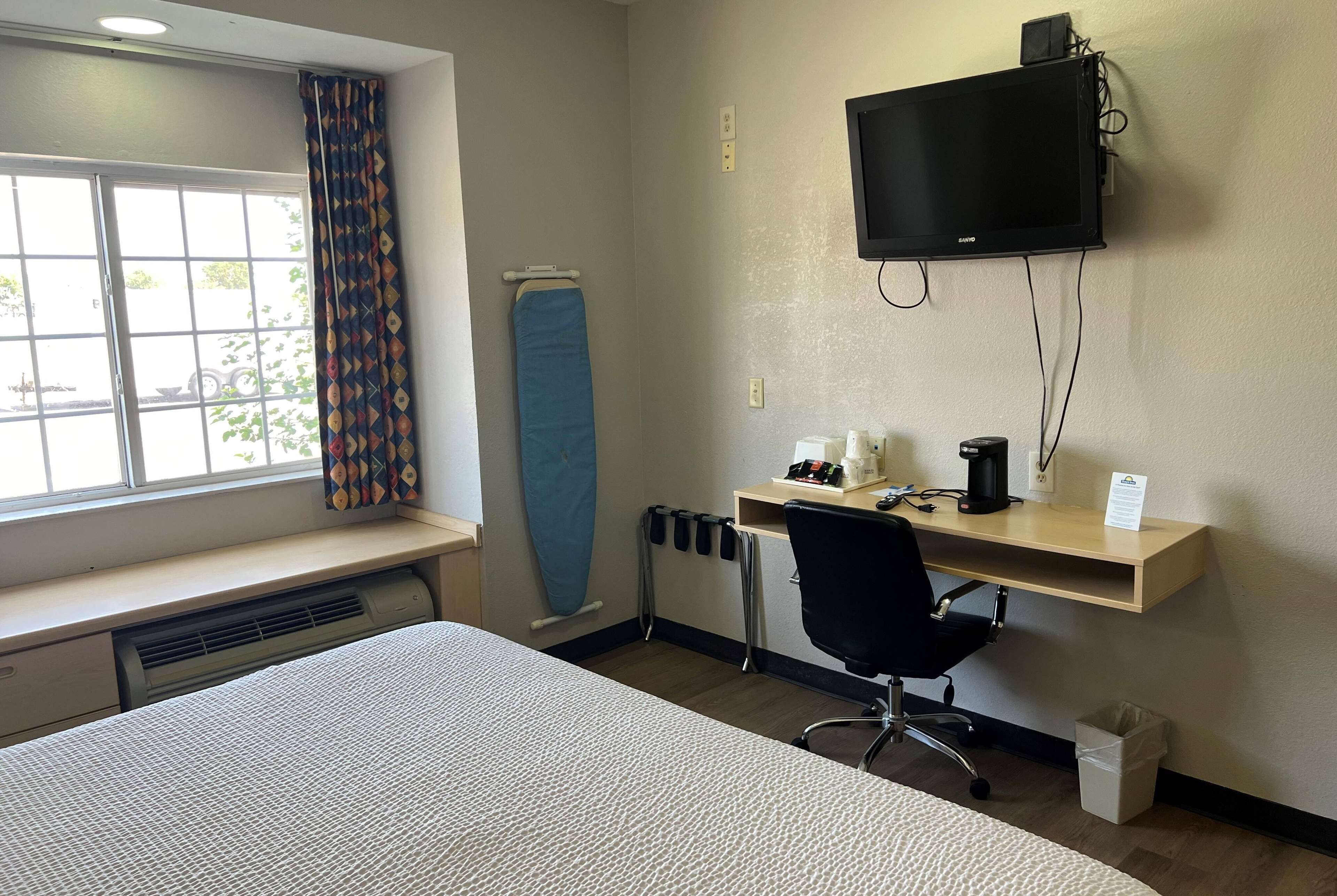 Escritorio, cortinas blackout y tabla de planchar con plancha 