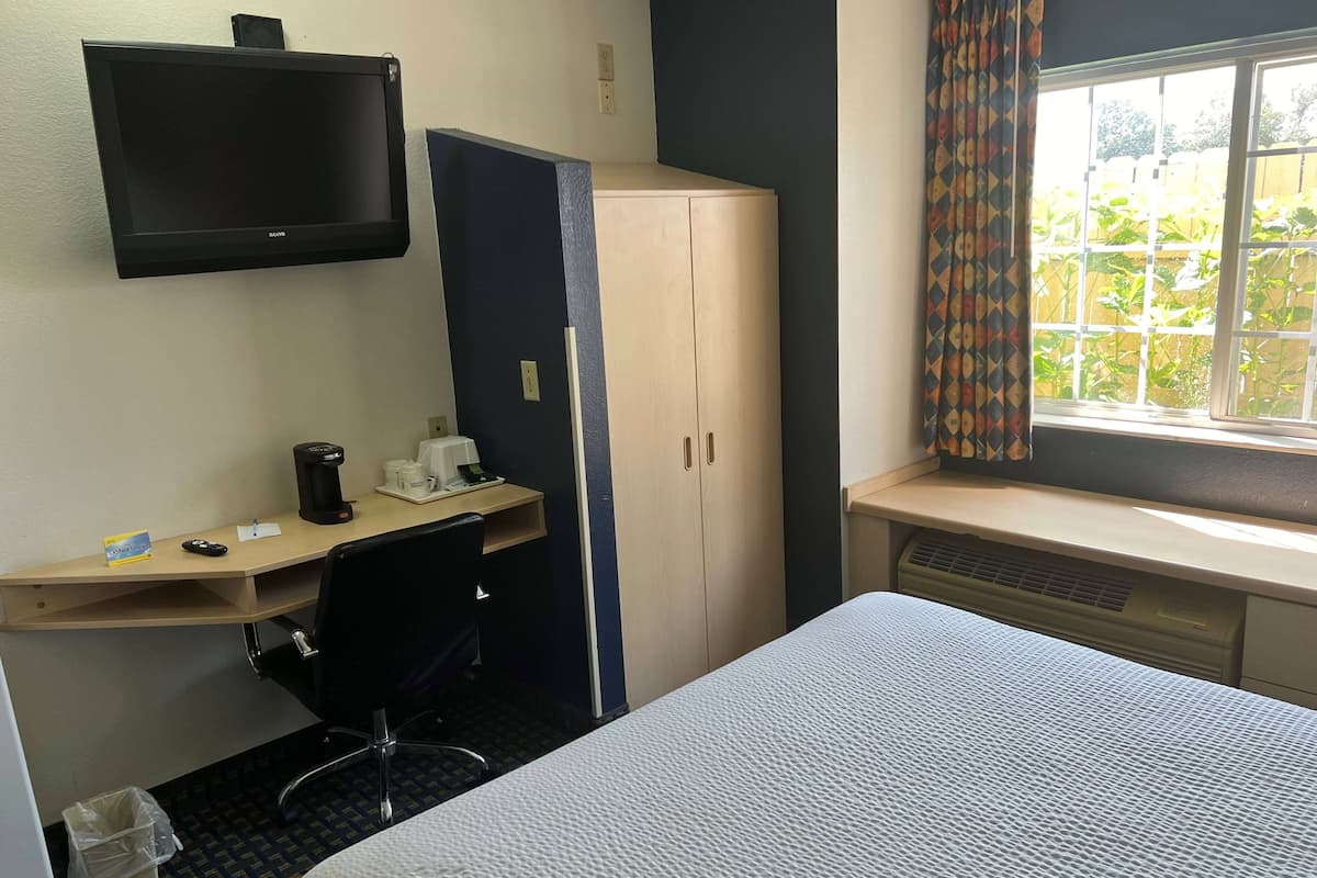 Escritorio, cortinas blackout y tabla de planchar con plancha