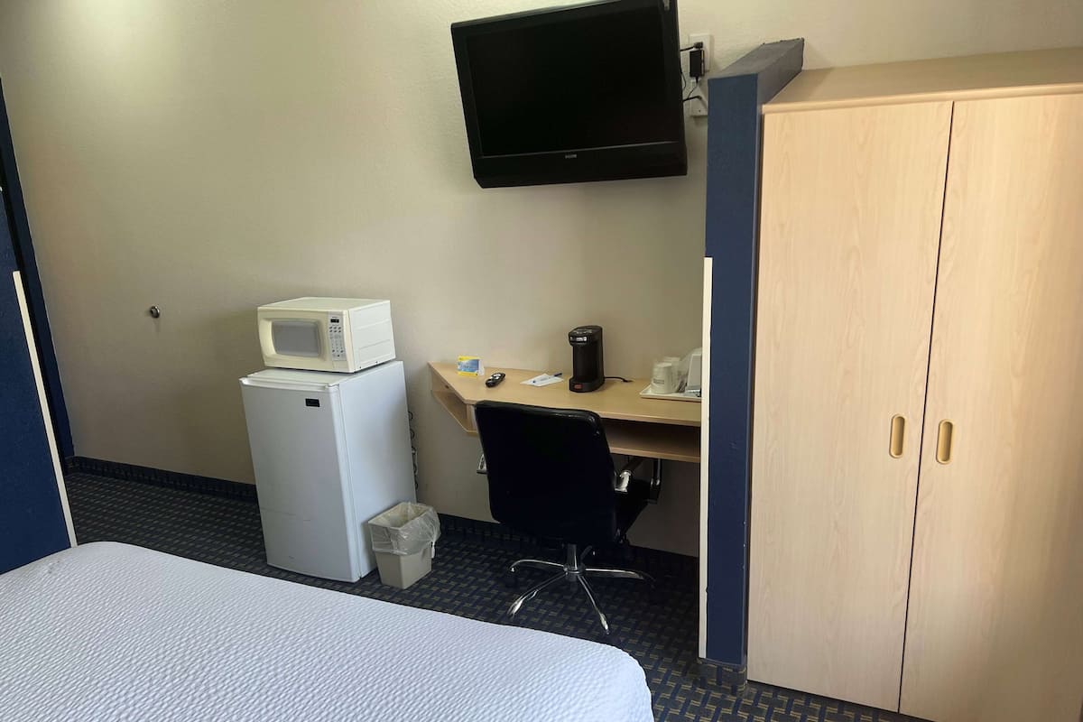 Escritorio, cortinas blackout y tabla de planchar con plancha