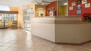 A reception area with a counter, a window, and a wall with various signs.