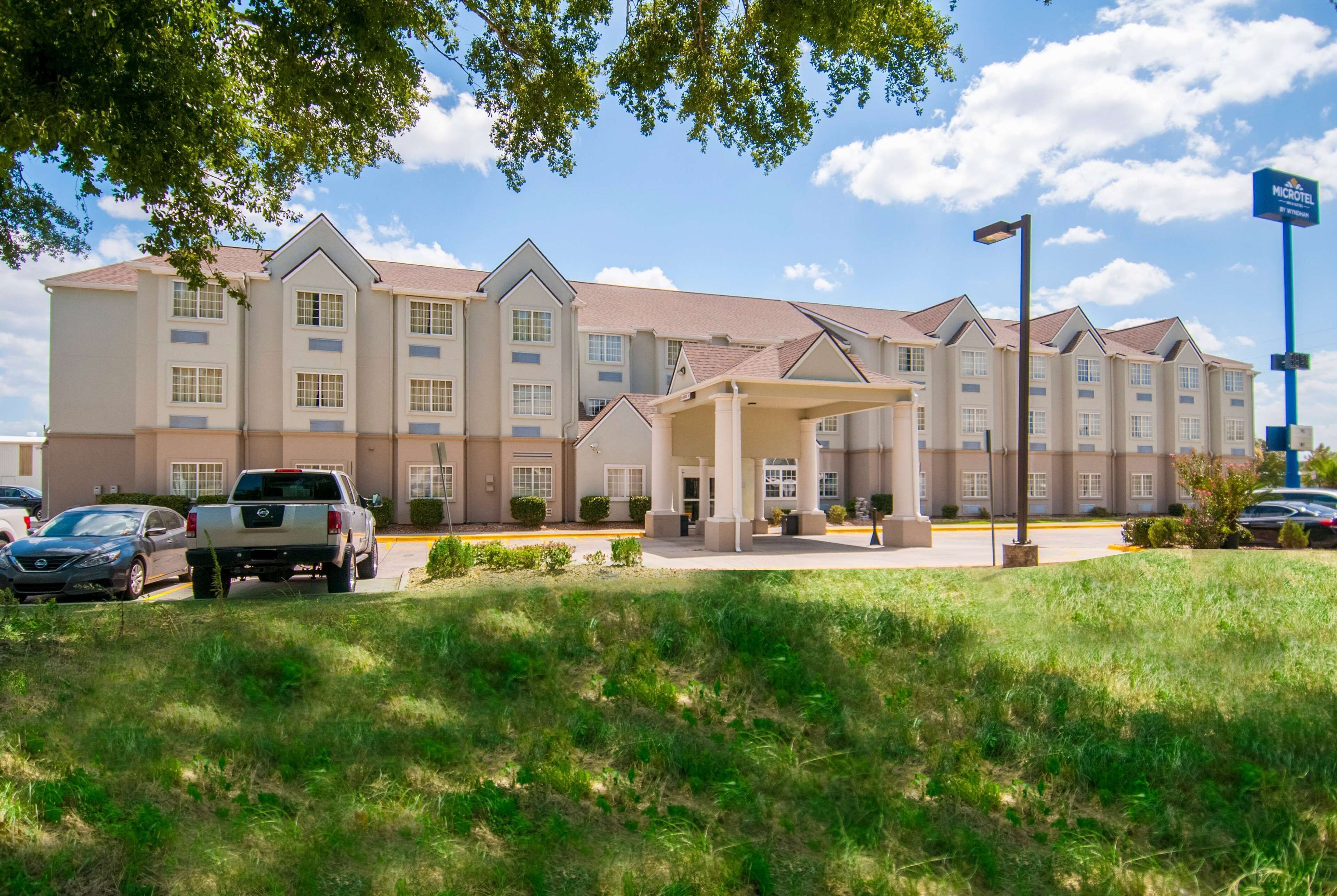 A multi-story hotel with a covered entrance, parking lot, and a sign indicating it is a Marriott hotel.