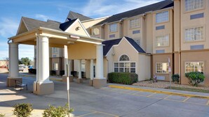 A hotel with a covered entrance, multiple windows, and a parking area. - Microtel Inn & Suites by Wyndham Scott/Lafayette (Scott)