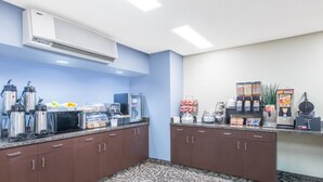 A kitchenette with coffee makers, a microwave, and a water dispenser.