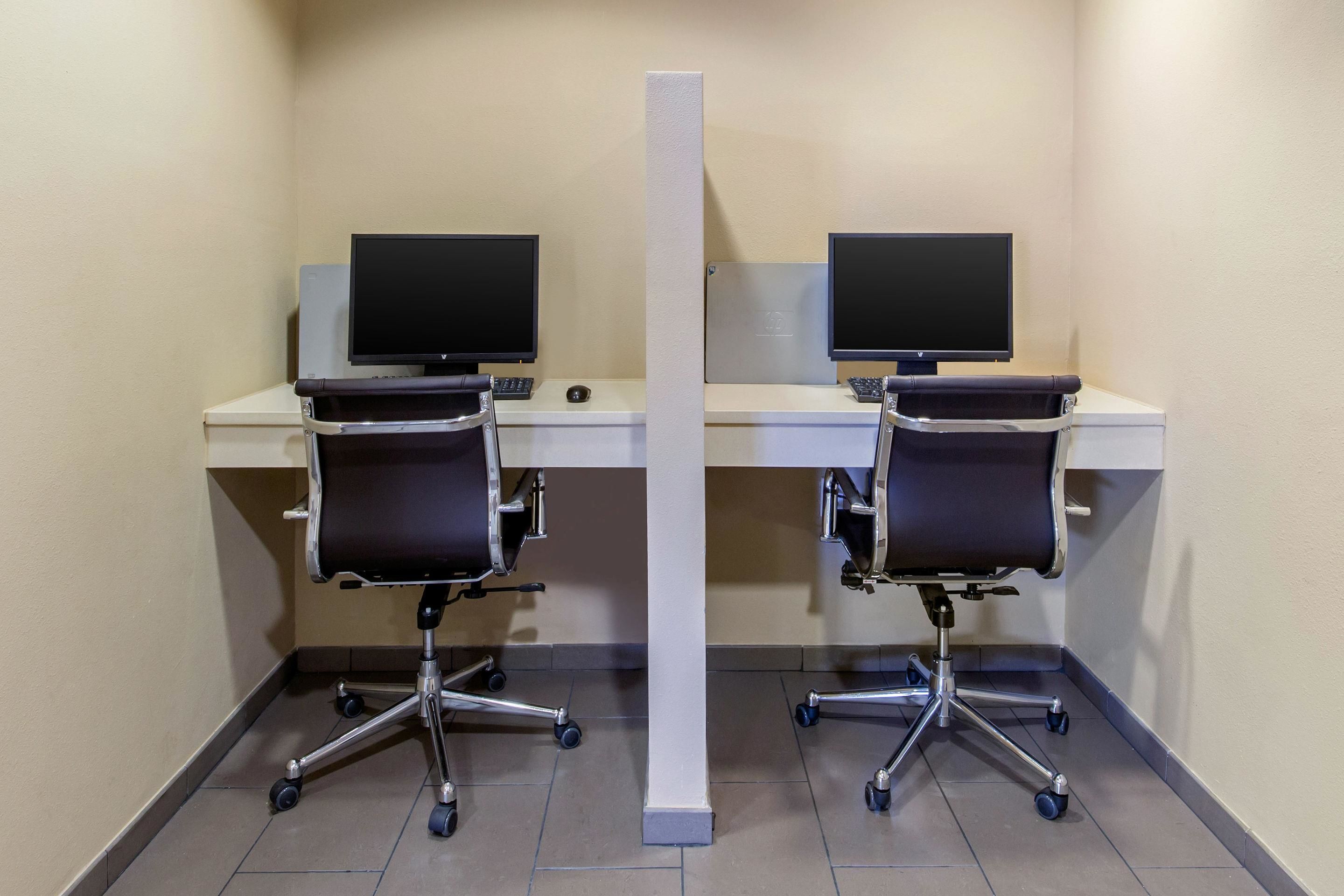 Deux chaises de bureau, deux bureaux et deux écrans d’ordinateur, le tout installé dans un coin de la pièce.