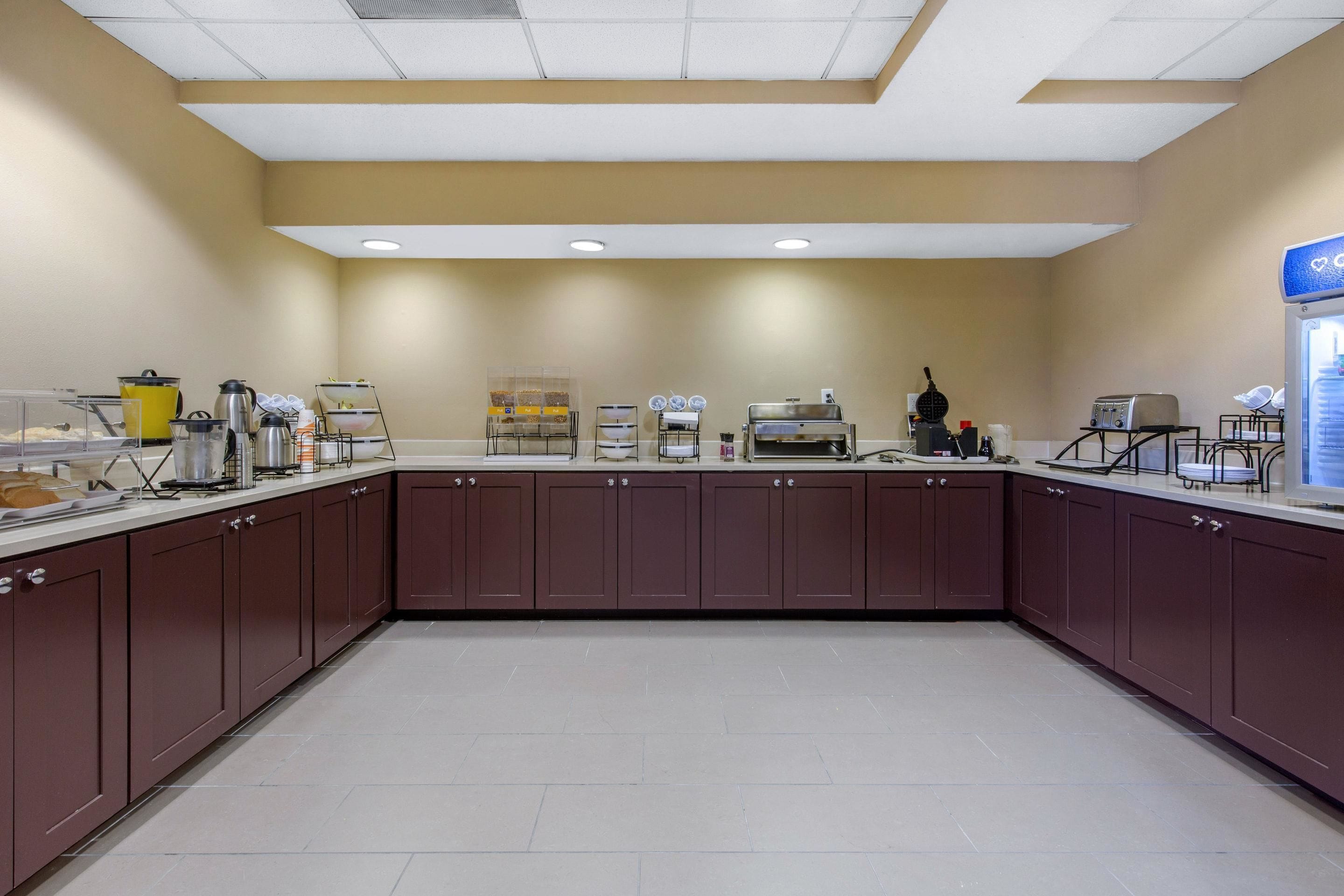 A kitchen area with cabinets, a coffee station, and a toaster.
