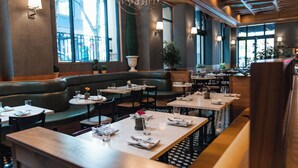 A restaurant with booths, tables, and a chandelier. - Dossier Hotel (Portland)
