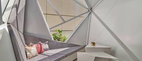 A modern room with a geometric design, a built-in seating area, and a small table.