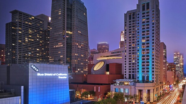 A cityscape with modern high-rise buildings, including a distinctive building with a large clock and a theater named "Blue Shield of California Theater". - W San Francisco (San Francisco)